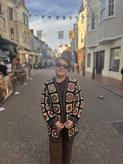 Customer wearing a granny-square crochet cardigan on a Brighton street