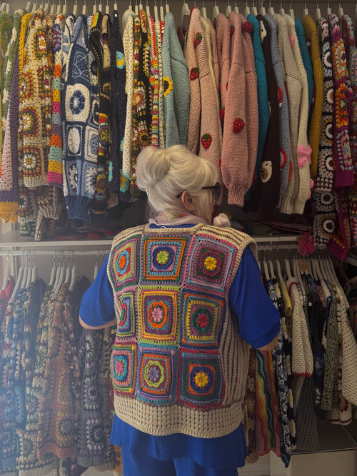 Customer trying on a granny-square vest inside the Brighton shop