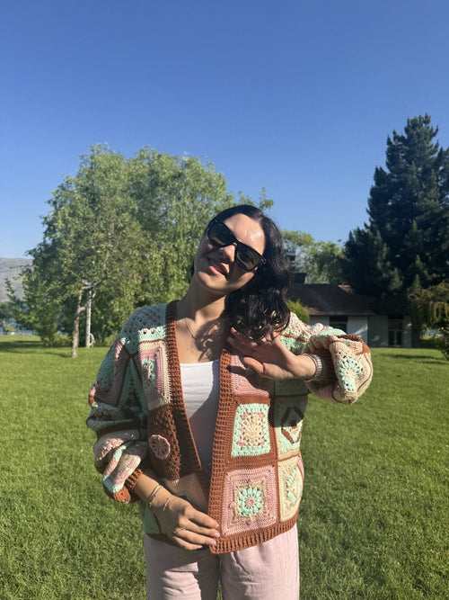 Customer in a green granny-square cardigan in a park