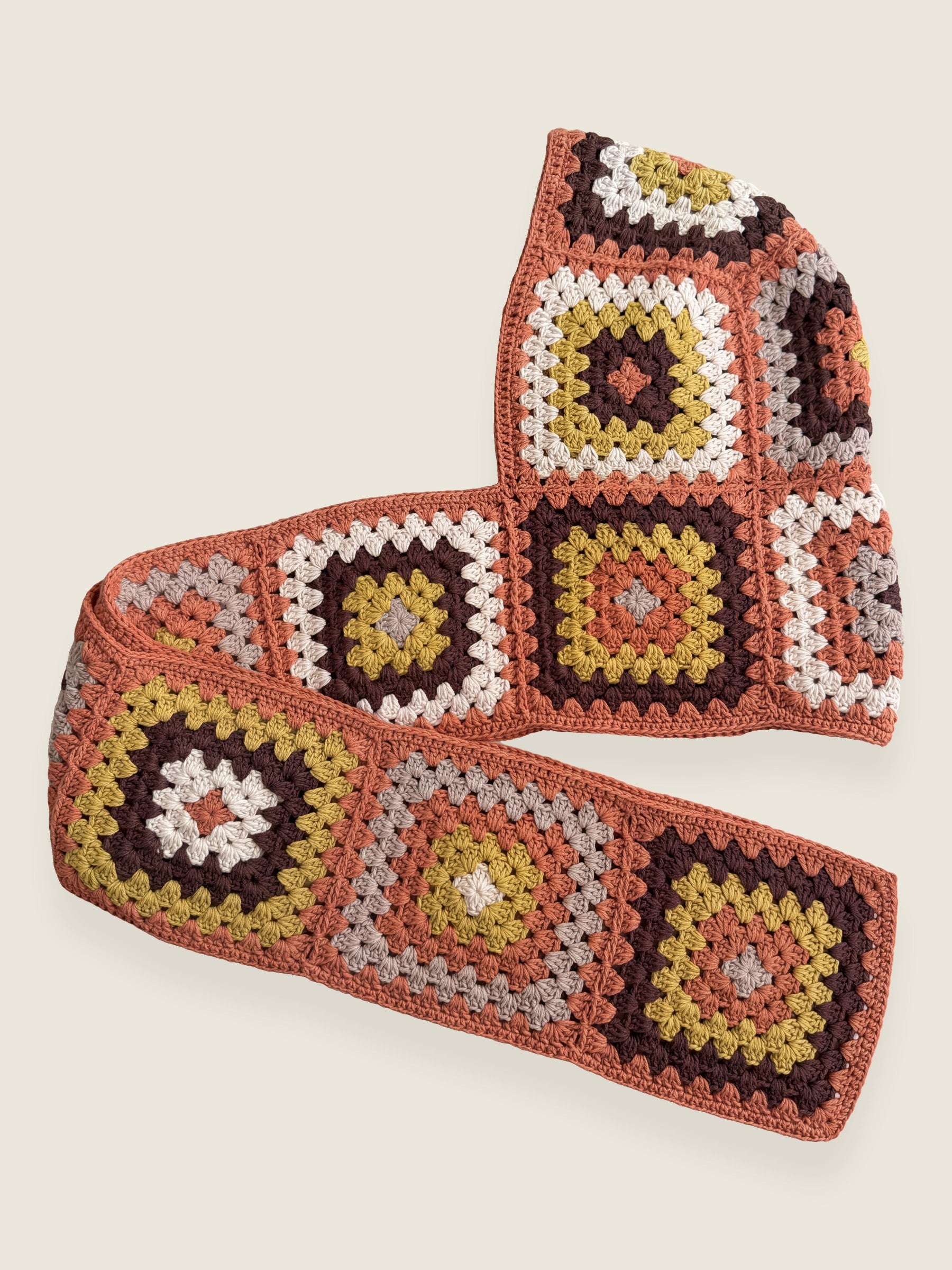 Terracotta granny-square crochet hooded scarf laid flat, hood and long scarf in one piece — handmade by Ana Chic