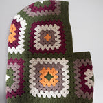 Olive green granny square balaclava laid flat, side view of the hood — handmade by Ana Chic