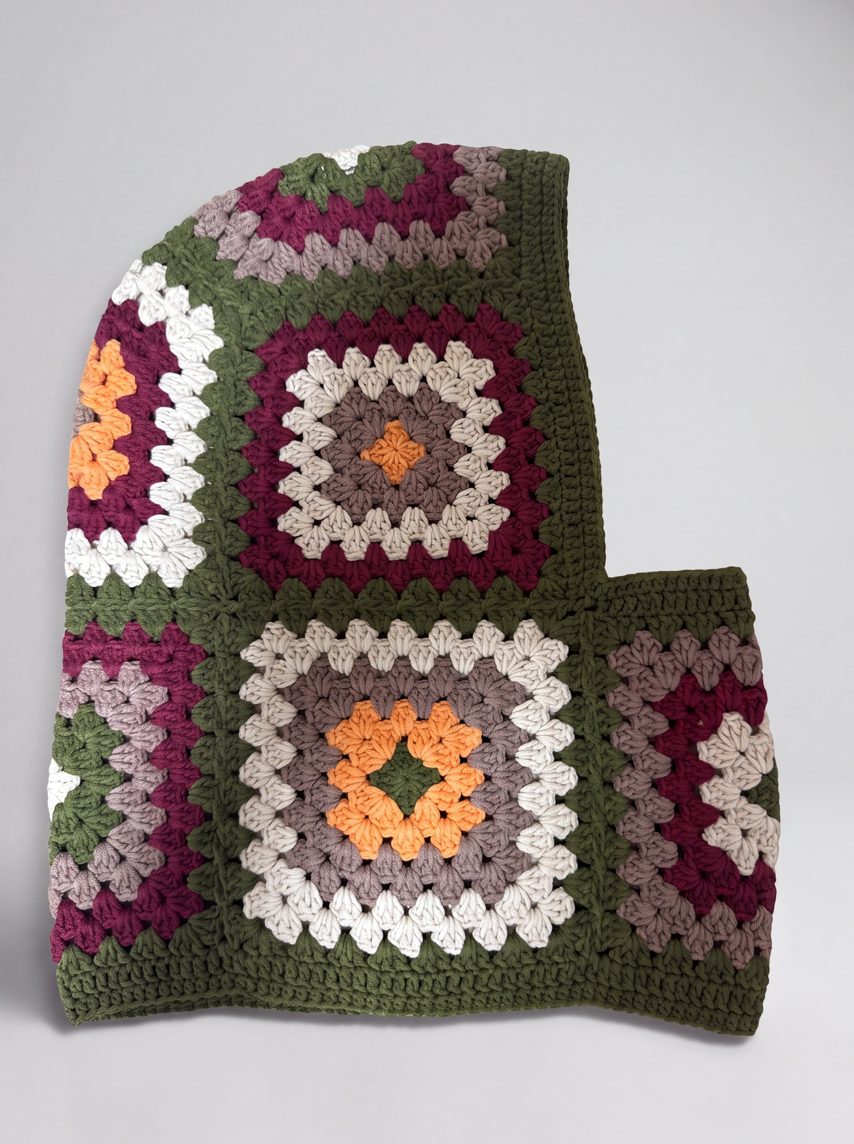 Olive green granny square balaclava laid flat, side view of the hood — handmade by Ana Chic