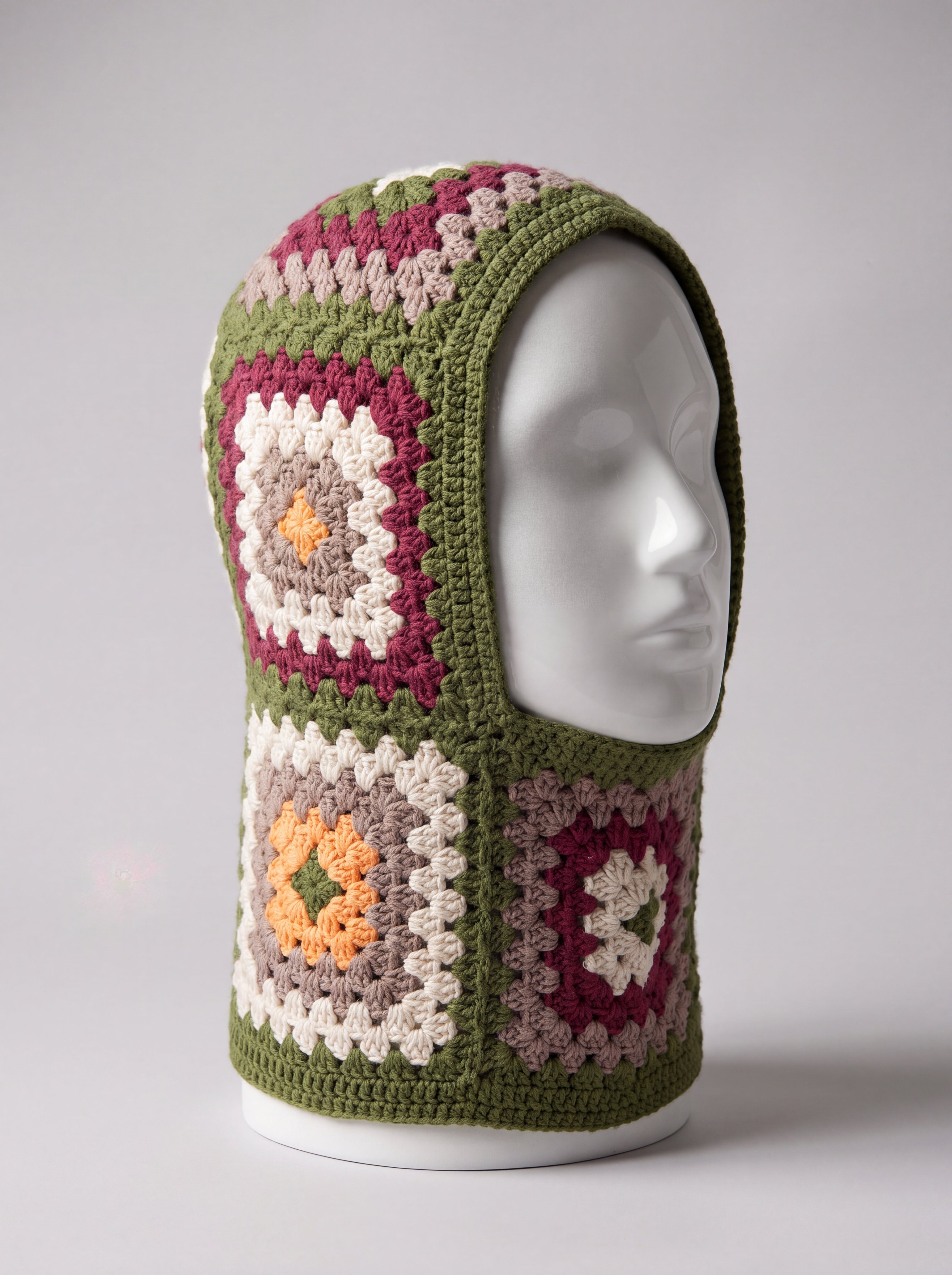 Olive green granny square balaclava on a display head, open face and deep neck section — handmade by Ana Chic