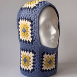 Denim blue and mustard granny square balaclava on a display head, open face and deep neck section — handmade by Ana Chic