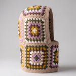 Sand and lilac granny square balaclava standing on its own, back view of the hood — handmade by Ana Chic