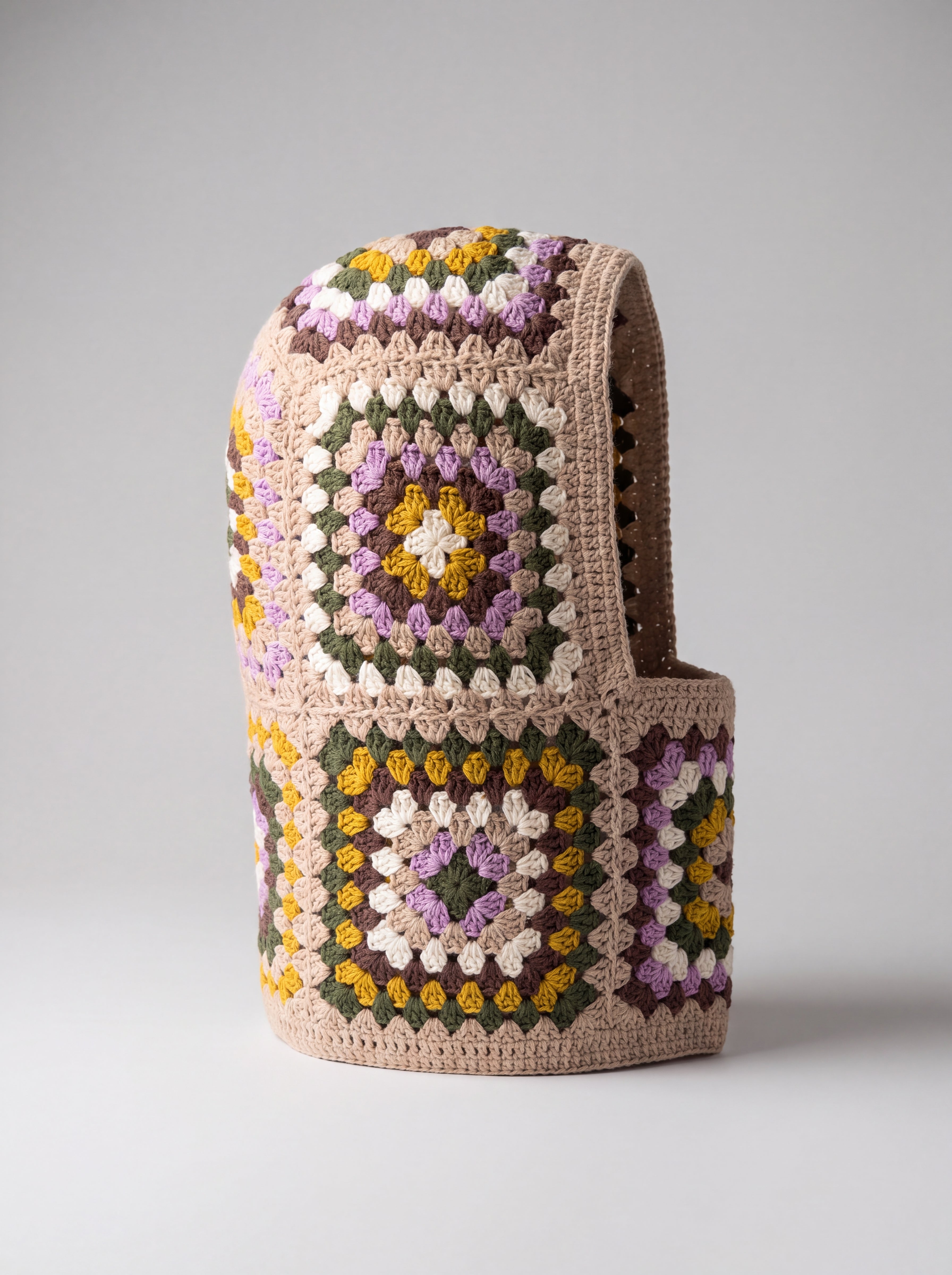 Sand and lilac granny square balaclava standing on its own, back view of the hood — handmade by Ana Chic