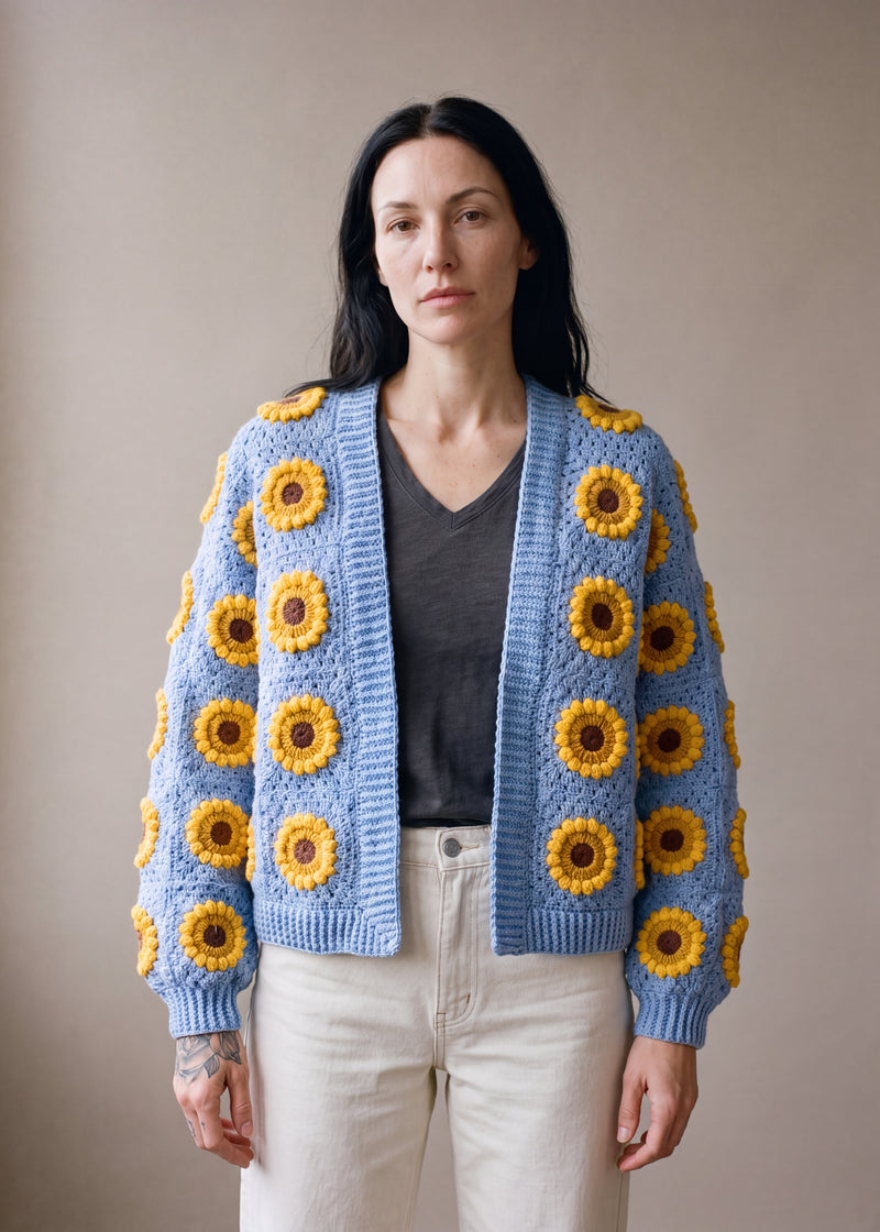3D Sunflower Blue Cardigan - Mid cornflower blue crocheted granny square cardigan with raised crochet sunflowers, worn by Ana Chic
