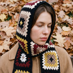 Black granny-square crochet hooded scarf worn with the hood up and the tails down the front — handmade by Ana Chic