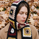 Black granny-square crochet hooded scarf worn with the hood up and the tails down the front — handmade by Ana Chic