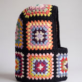 Black pastel granny square balaclava standing on its own, back view of the hood — handmade by Ana Chic