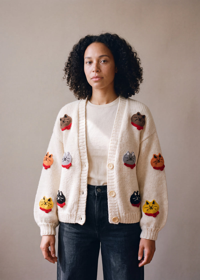 Cream chunky knit cardigan with crocheted cat faces in red scarves, worn open over a white top — handmade by Ana Chic
