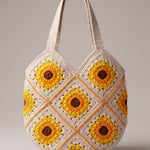 Front of the cream crochet shoulder bag with sunflower granny squares, orange seams and two wide straps — handmade by Ana Chic