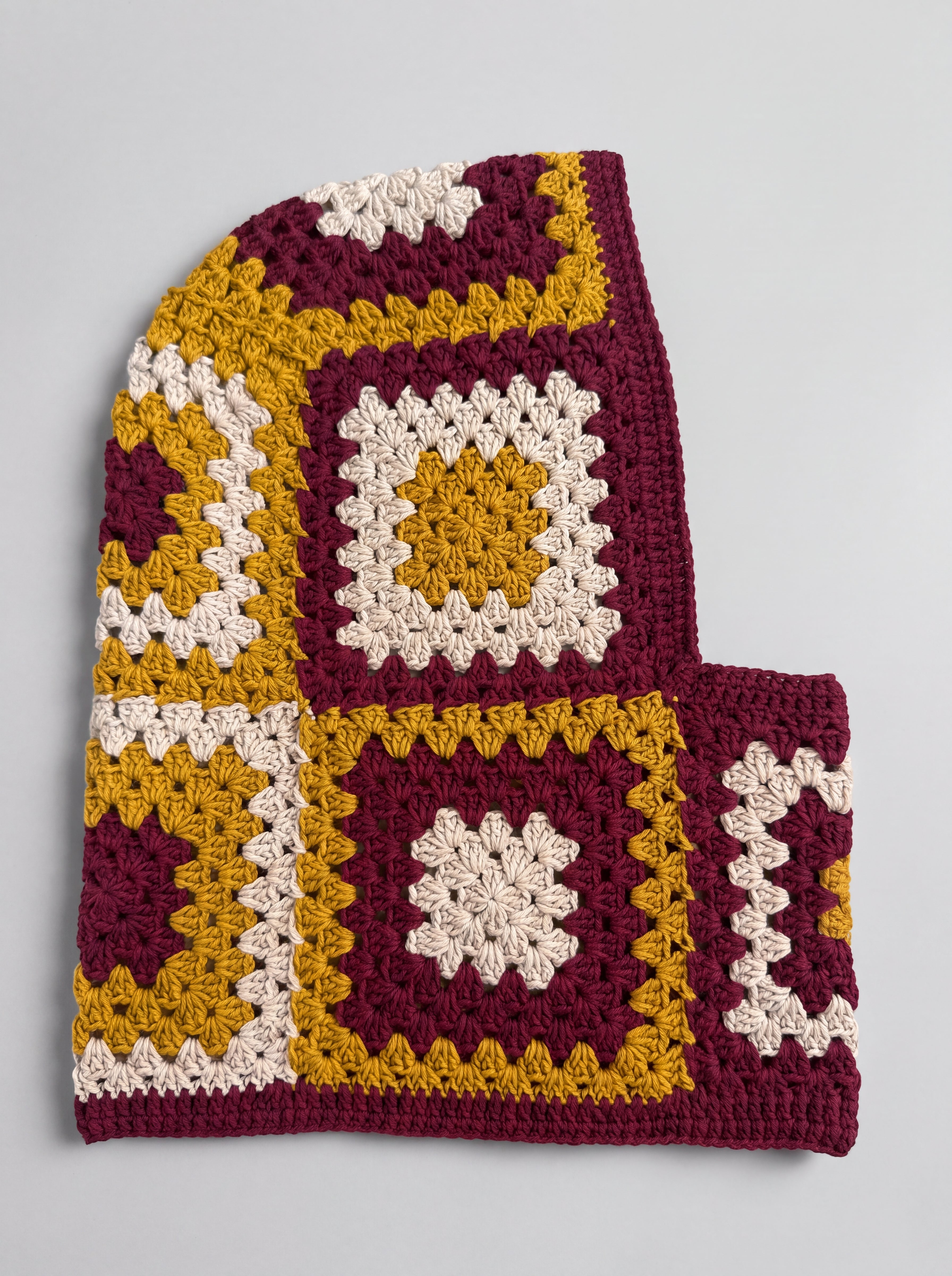 Burgundy and mustard granny square balaclava laid flat, side view of the hood — handmade by Ana Chic