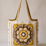 Front of the mustard crochet tote bag with its raised crocheted medallion — handmade by Ana Chic