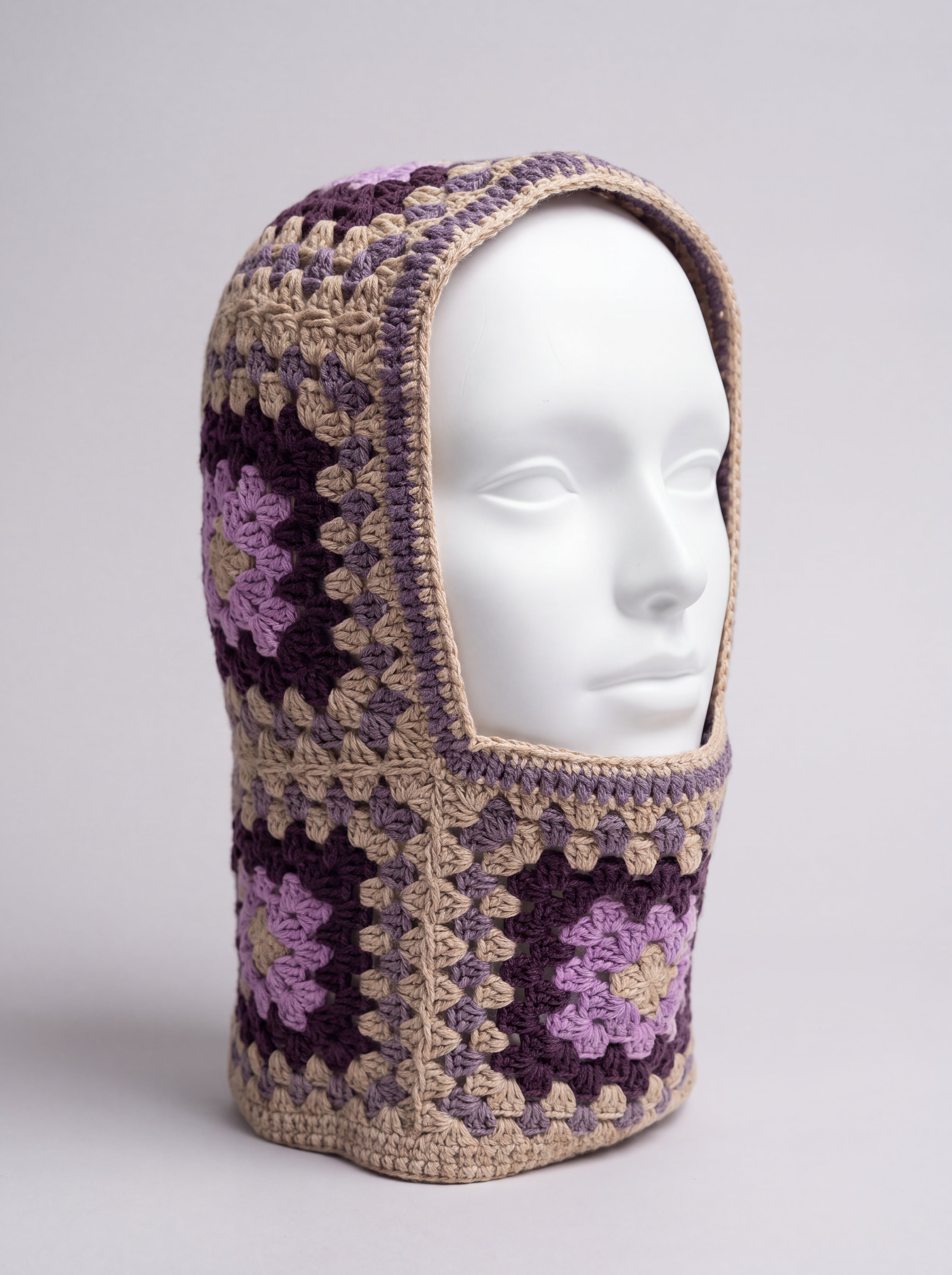 Sand and plum granny square balaclava on a display head, open face and deep neck section — handmade by Ana Chic
