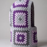 Grey and purple granny square balaclava standing on its own, back view of the hood — handmade by Ana Chic