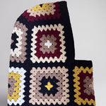 Black and burgundy granny square balaclava laid flat, side view of the hood — handmade by Ana Chic