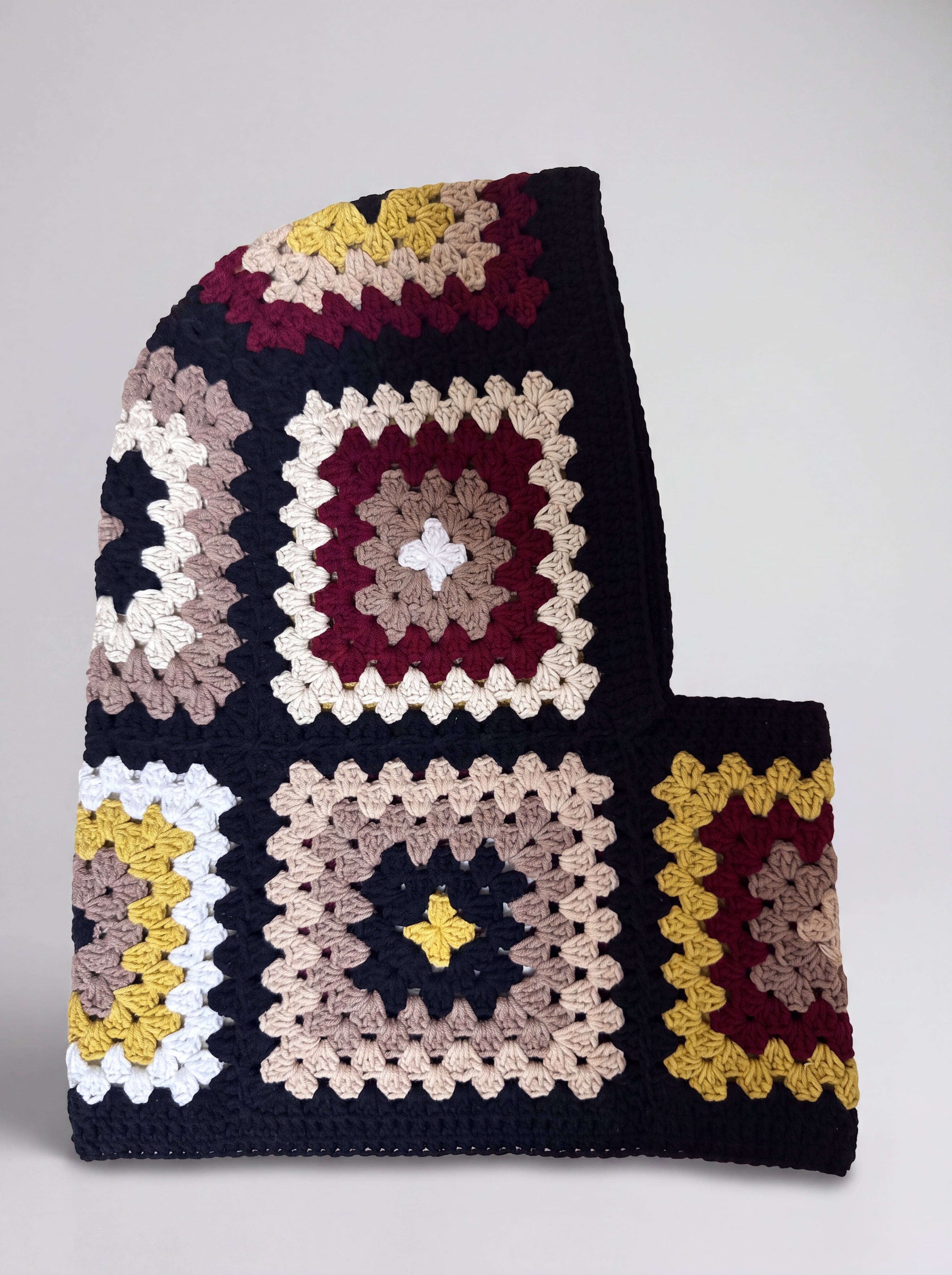 Black and burgundy granny square balaclava laid flat, side view of the hood — handmade by Ana Chic