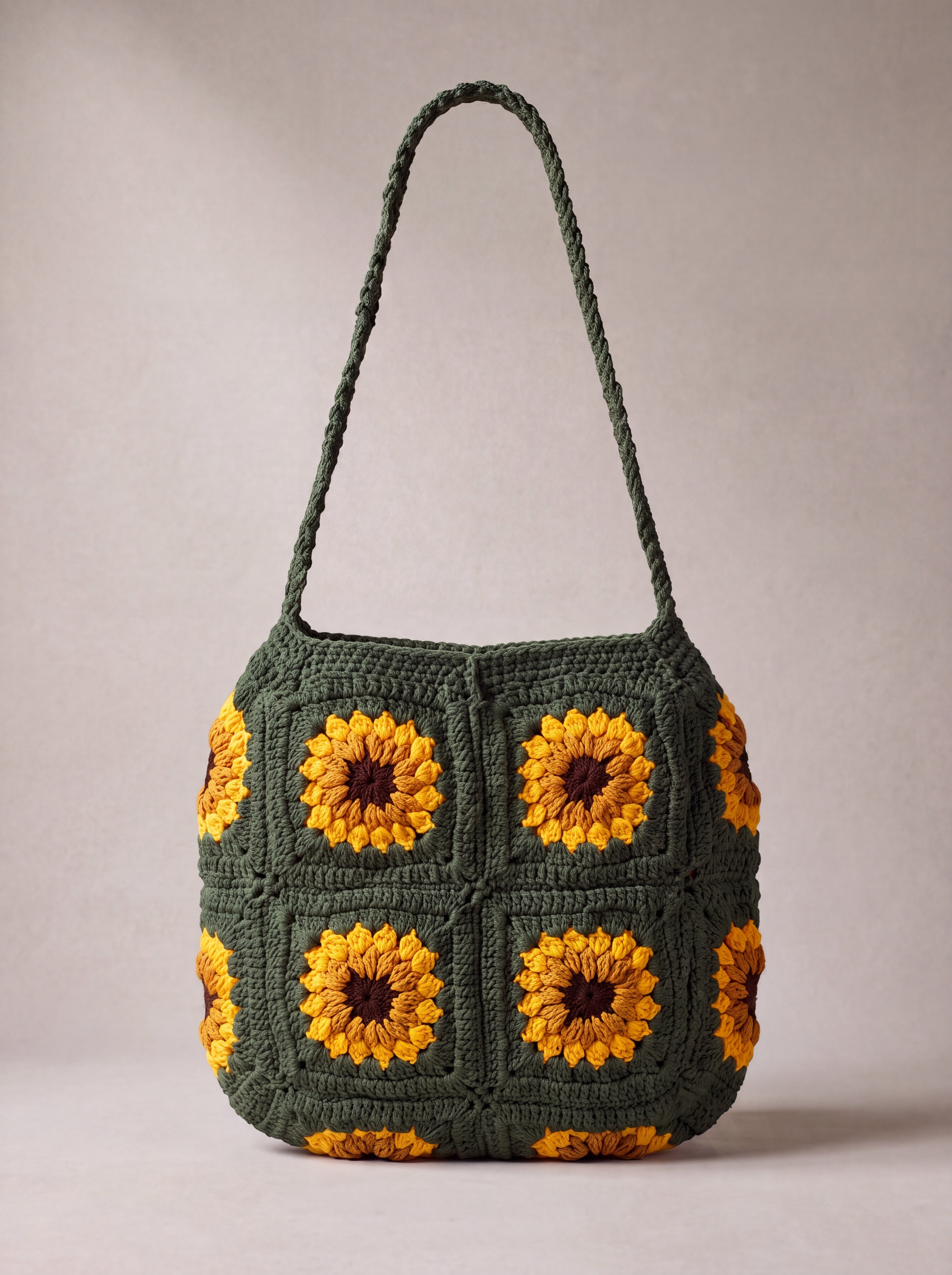 Back of the dark green crochet crossbody bag with its sunflower squares and adjustable strap — handmade by Ana Chic
