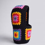 Black rainbow granny square balaclava standing on its own, back view of the hood — handmade by Ana Chic