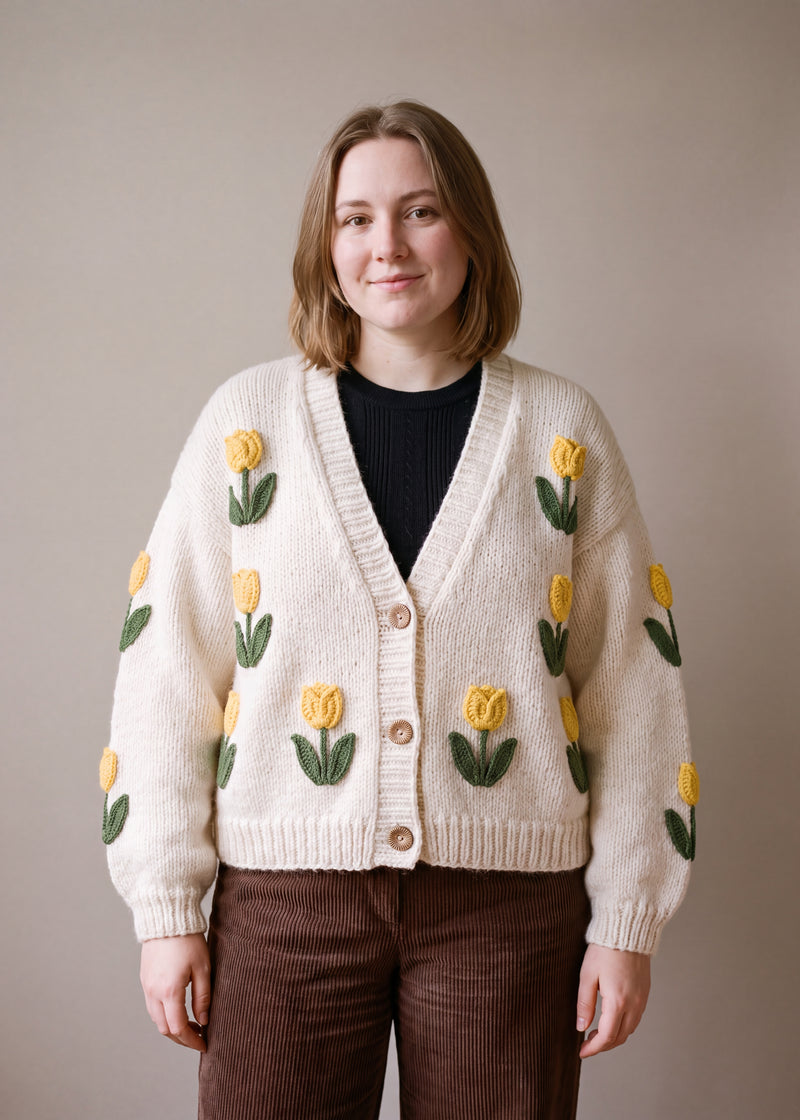 White Tulip Cardigan - cream chunky hand-knitted wool cardigan with crocheted motifs, worn open over a plain top by Ana Chic