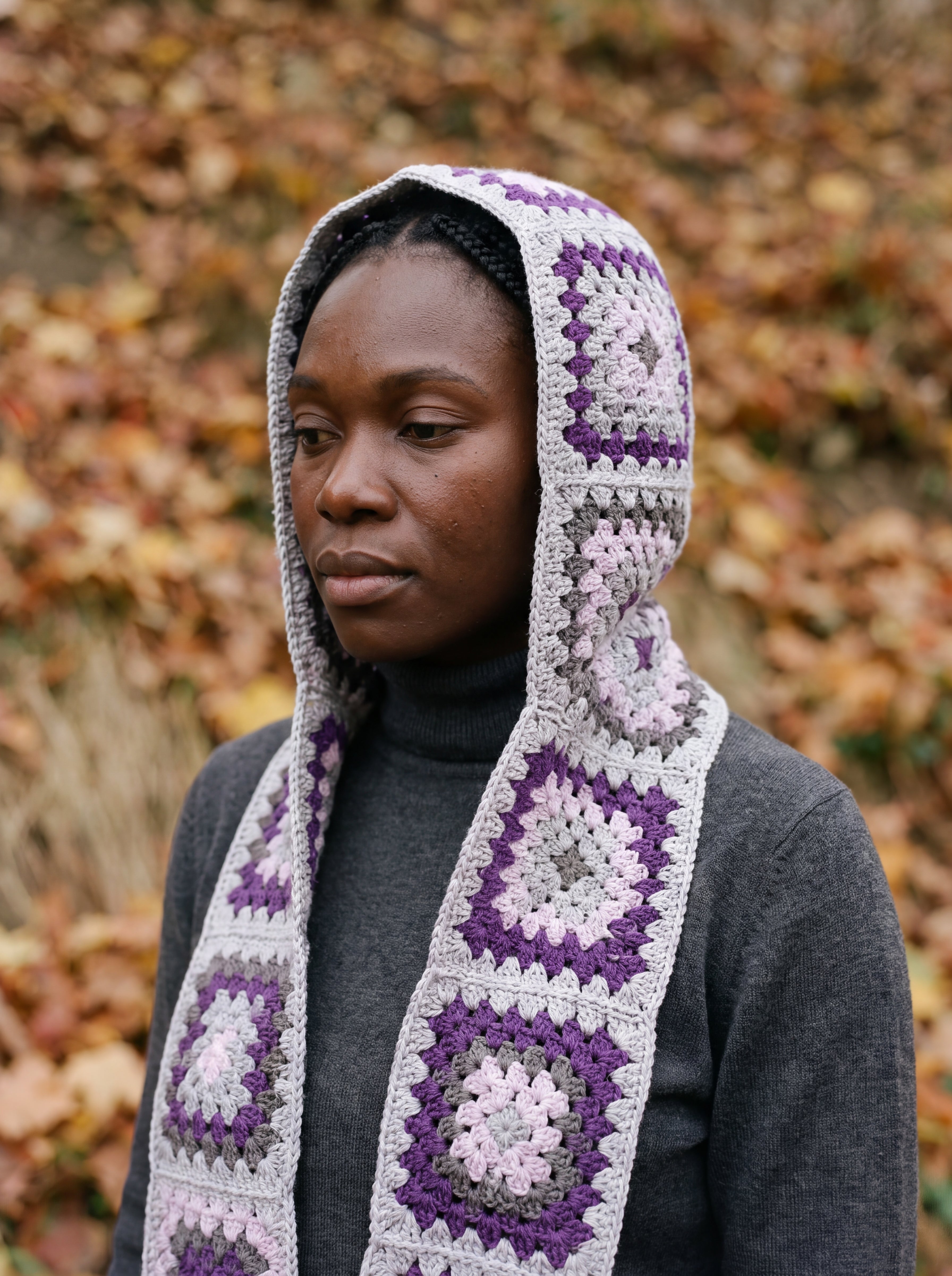 Grey granny-square crochet hooded scarf worn with the hood up and the tails down the front — handmade by Ana Chic