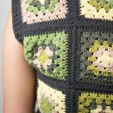 Close view of green and cream crochet squares framed in charcoal on the slipover — handmade by Ana Chic