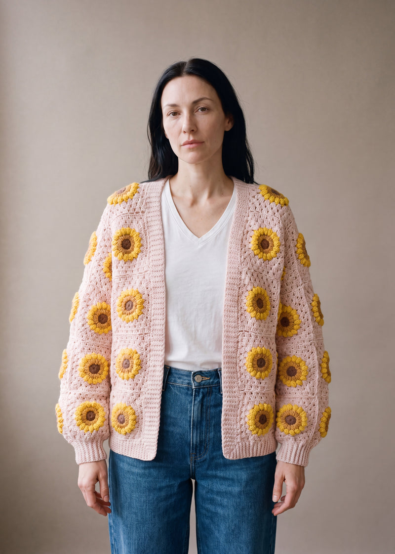 Sunflower Cardi – Pink - Pale blush-pink crocheted crocheted granny square cardigan with raised crochet sunflowers, worn by Ana Chic