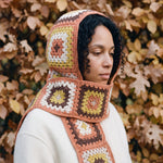 Terracotta granny-square crochet hooded scarf worn with the hood up and the tails down the front — handmade by Ana Chic