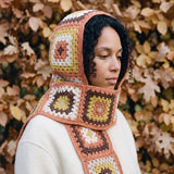 Terracotta granny-square crochet hooded scarf worn with the hood up and the tails down the front — handmade by Ana Chic