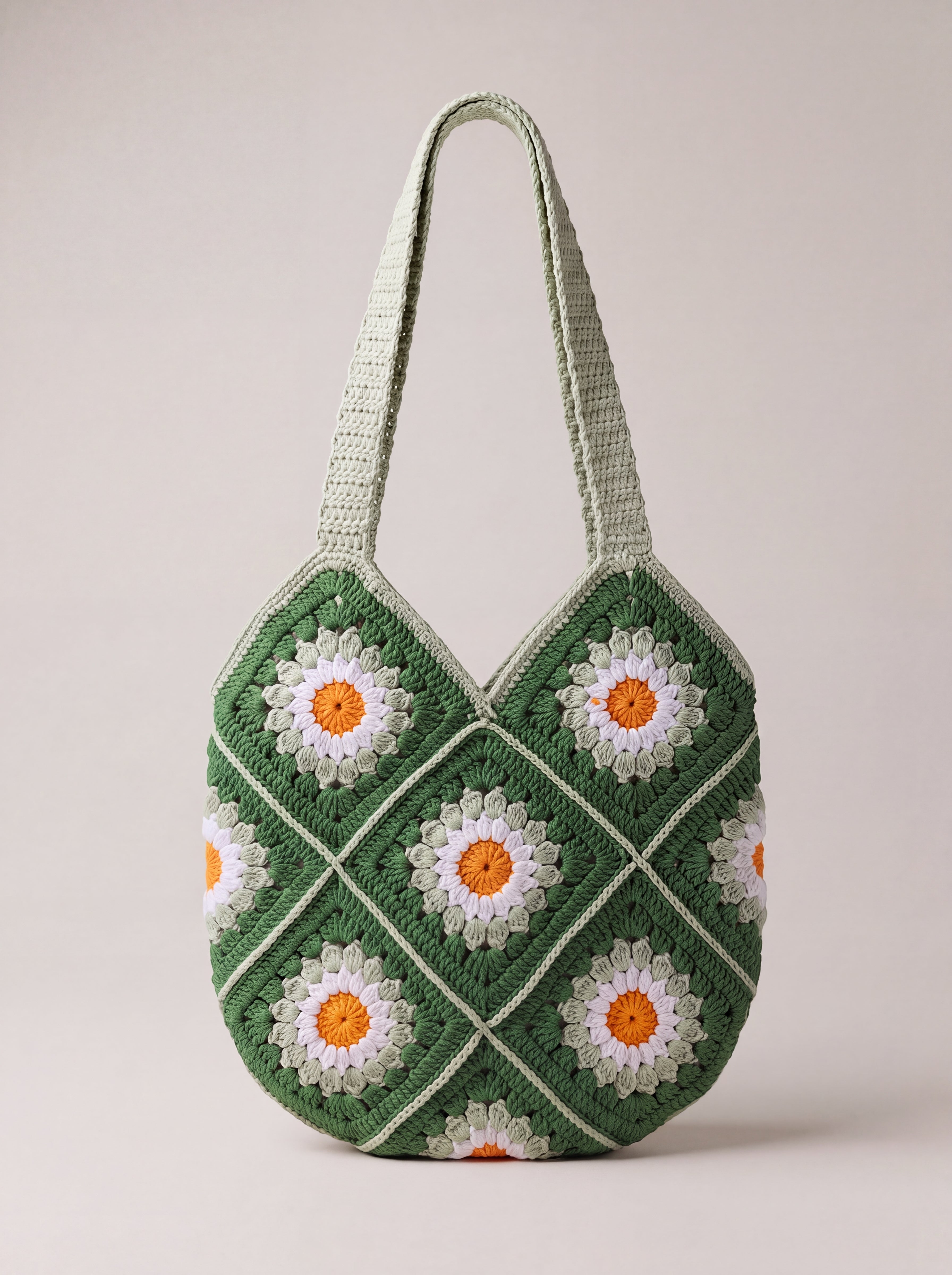 Back of the green crochet shoulder bag with its daisy granny squares and two shoulder straps — handmade by Ana Chic