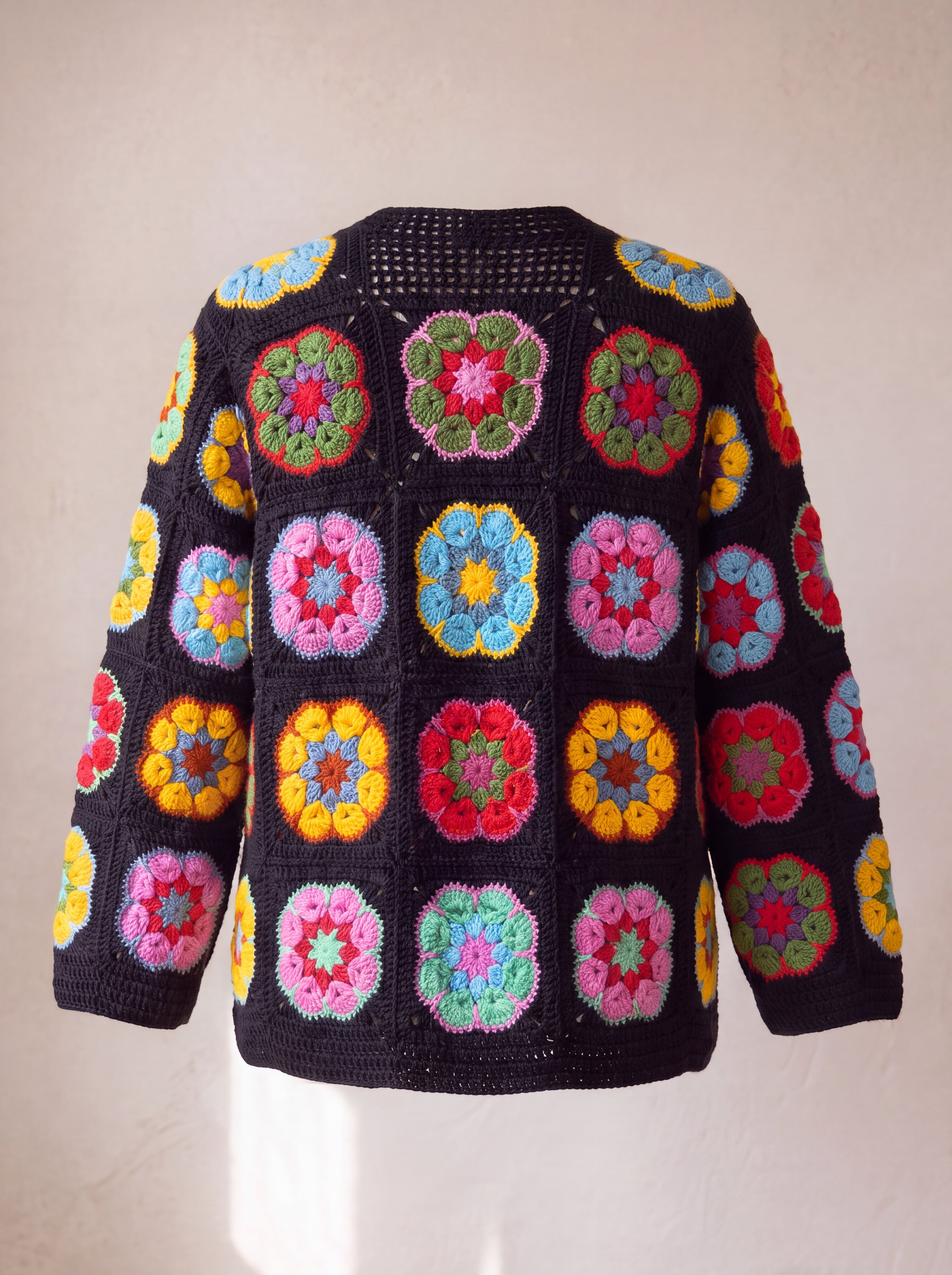 Black crochet cardigan with hexagonal African-flower blocks in pink, yellow, red and blue, back view with openwork mesh neck band - handmade by Ana Chic