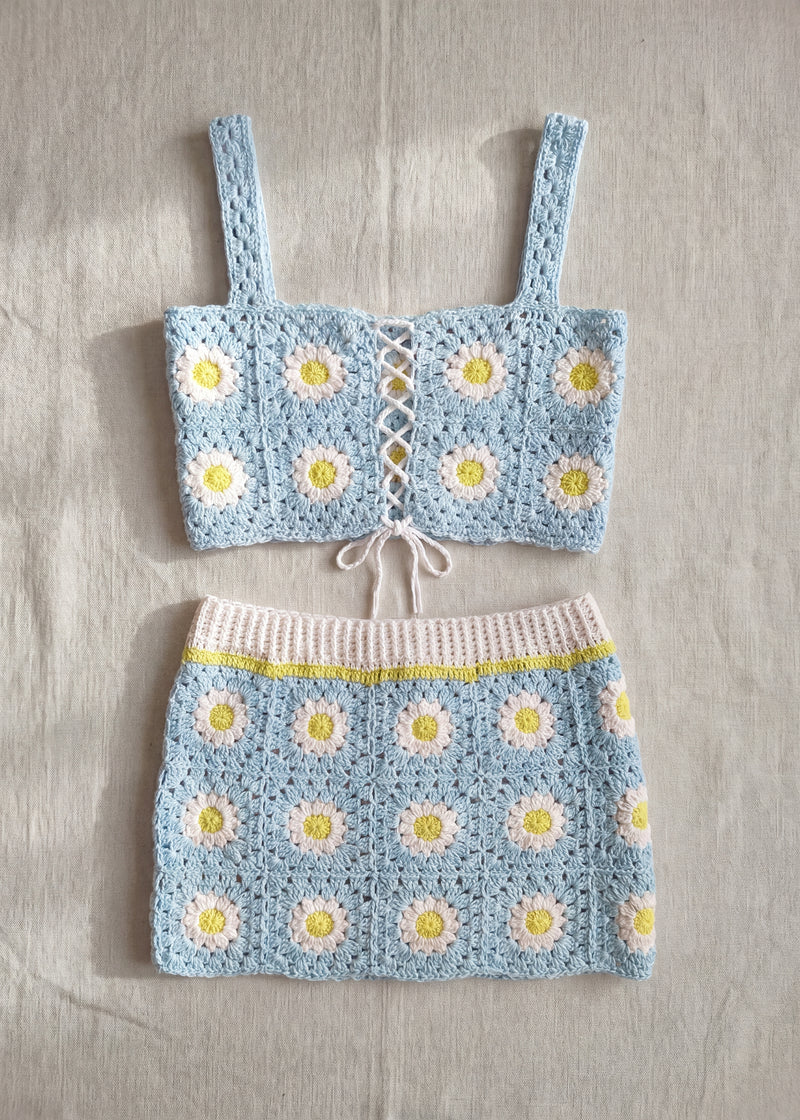 Pale blue crochet daisy crop top and matching skirt laid flat - handmade by Ana Chic