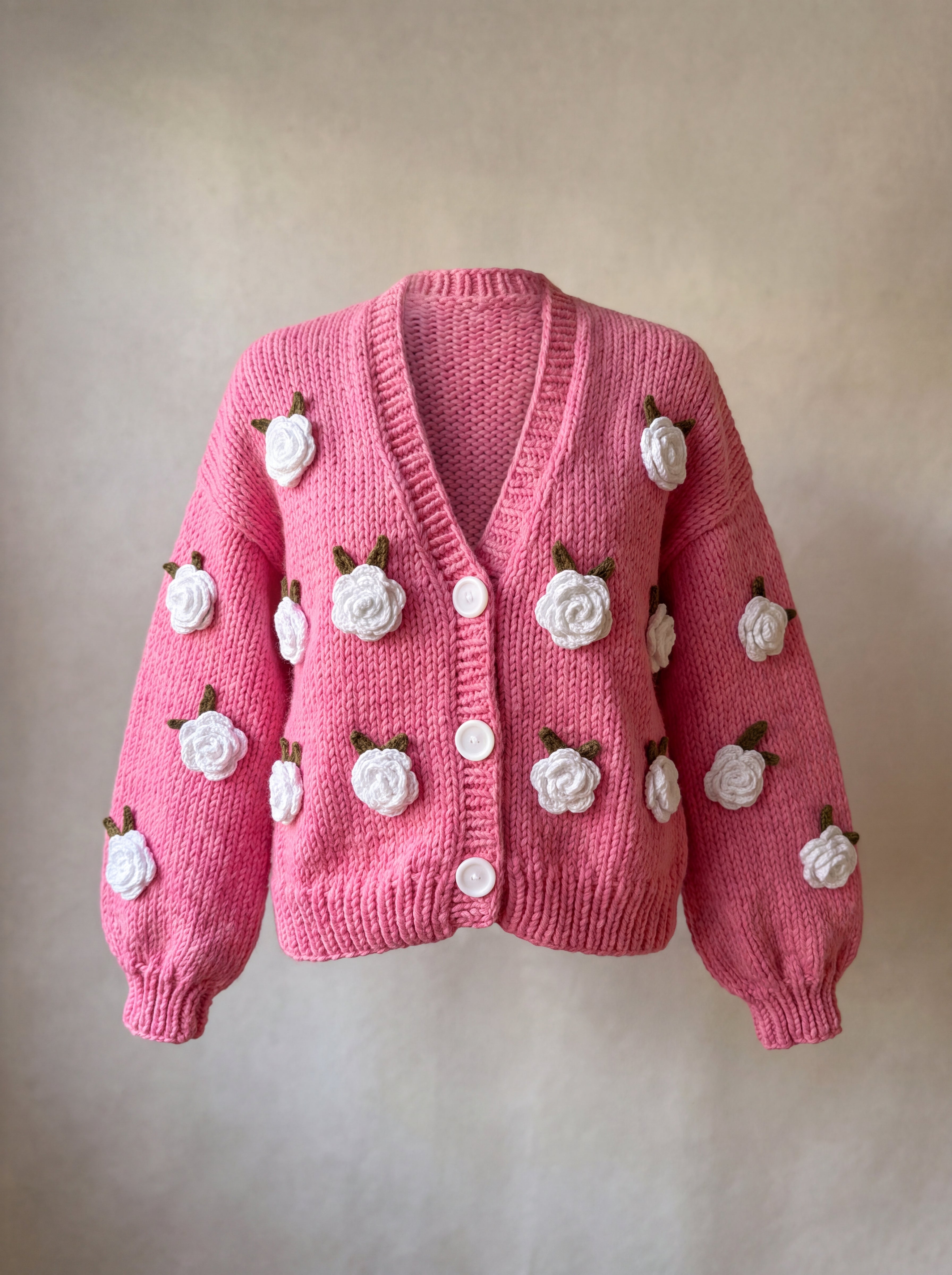 Rose Bubblegum cardigan front — bubblegum pink chunky hand-knitted wool cardigan with crocheted white roses and white buttons, handmade by Ana Chic