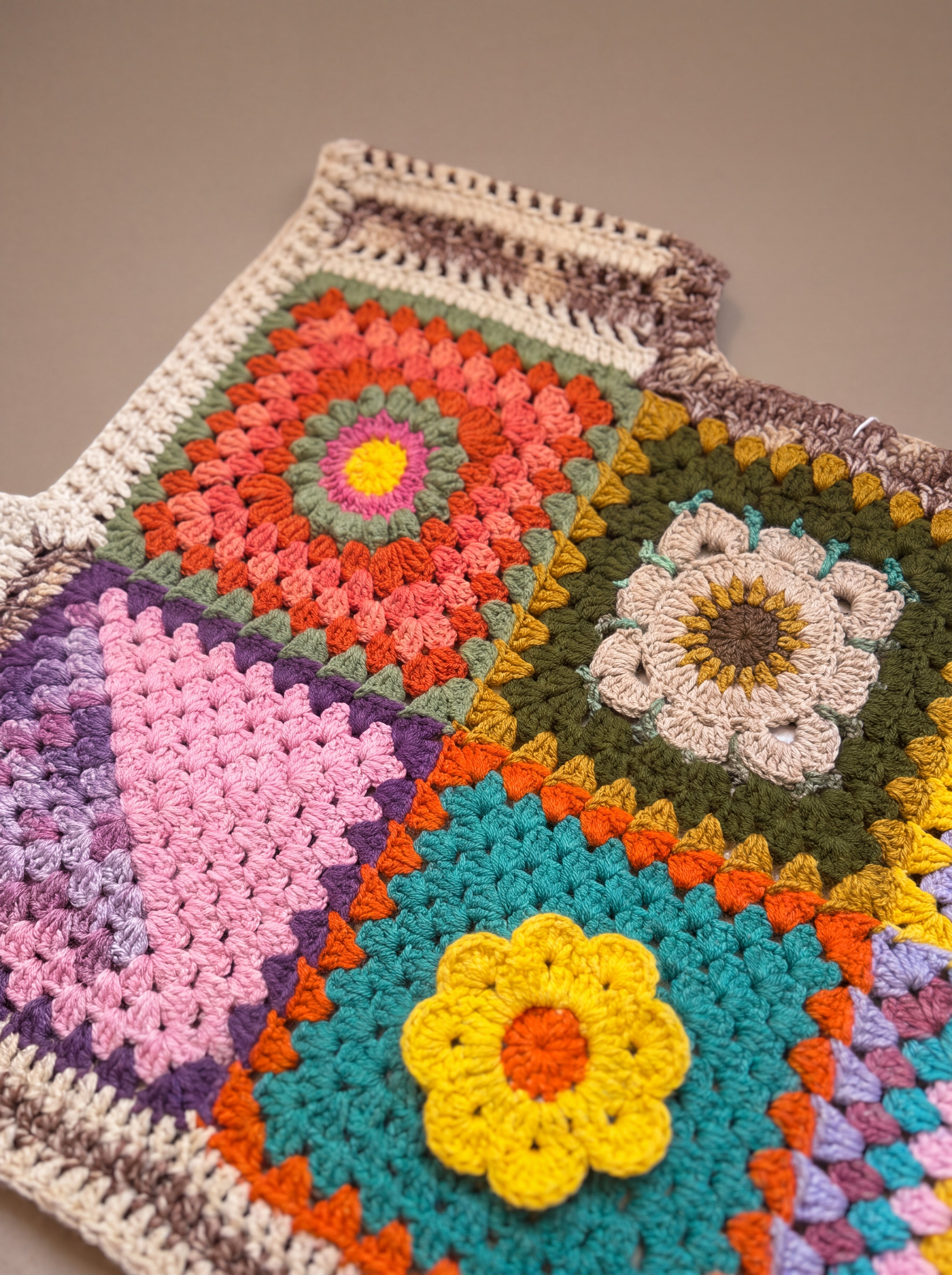 Close-up of the Bouquet Button Vest: hand-crocheted squares, each one a different design
