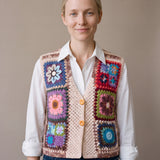 Woman wearing the Bouquet Button Vest, a handmade granny square crochet vest, over a white shirt and dark jeans