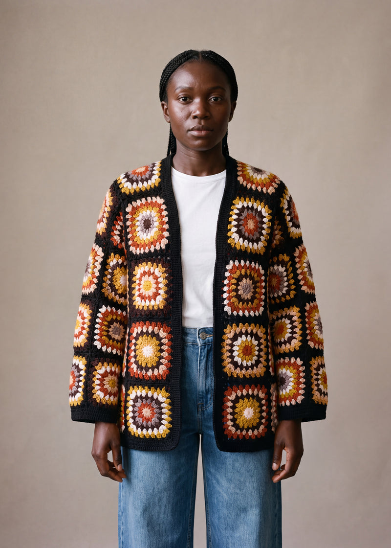 Black Boho Cardi worn by a model, open granny-square crochet cardigan in rust, mustard and cream over a white tee