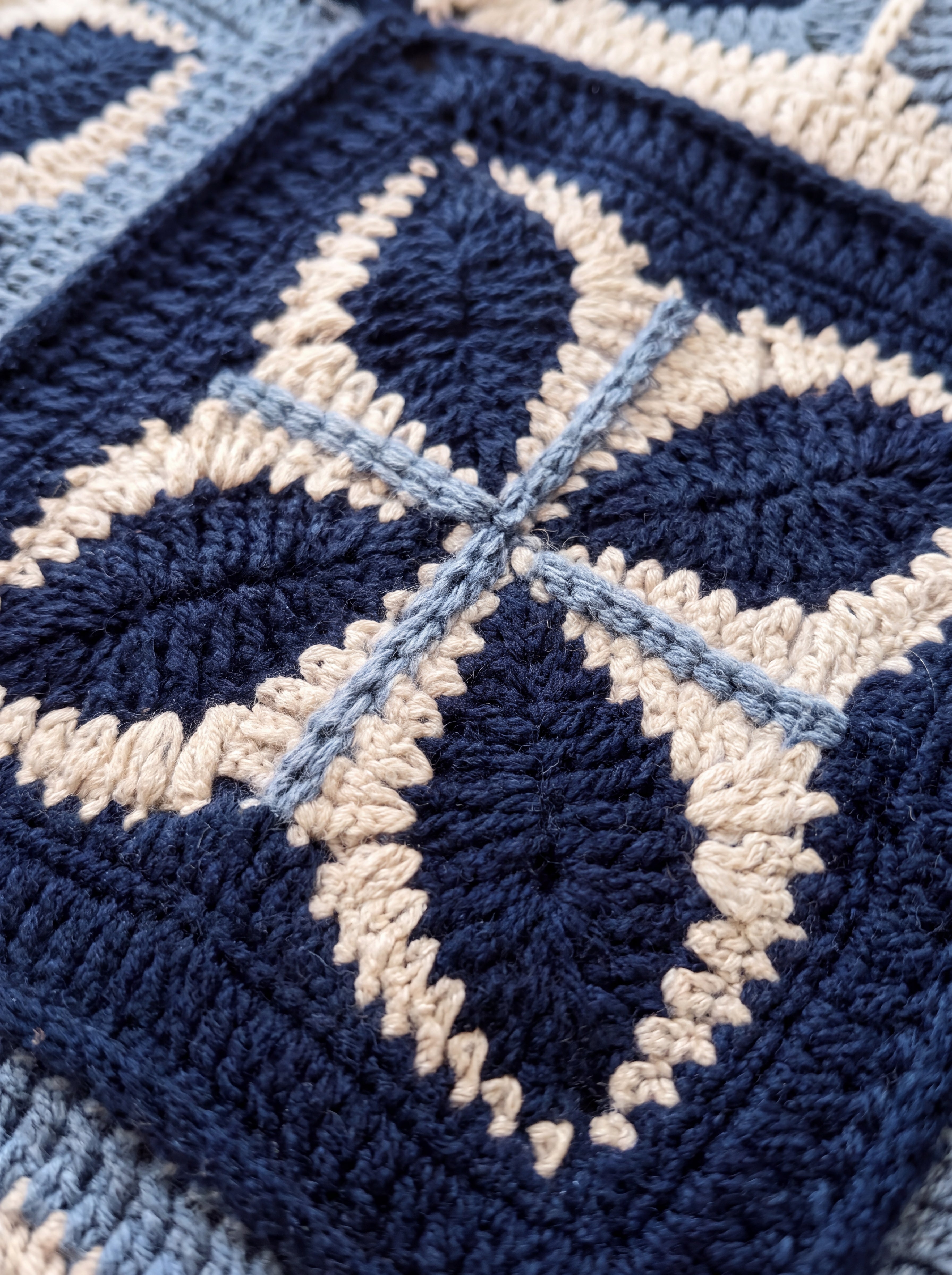 Macro of a hand-crocheted four-leaf square on the Sampler Cardigan in Navy