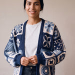 Woman wearing the Sampler Cardigan in Navy, a hand-crocheted granny-square cardigan, over a plain t-shirt and jeans