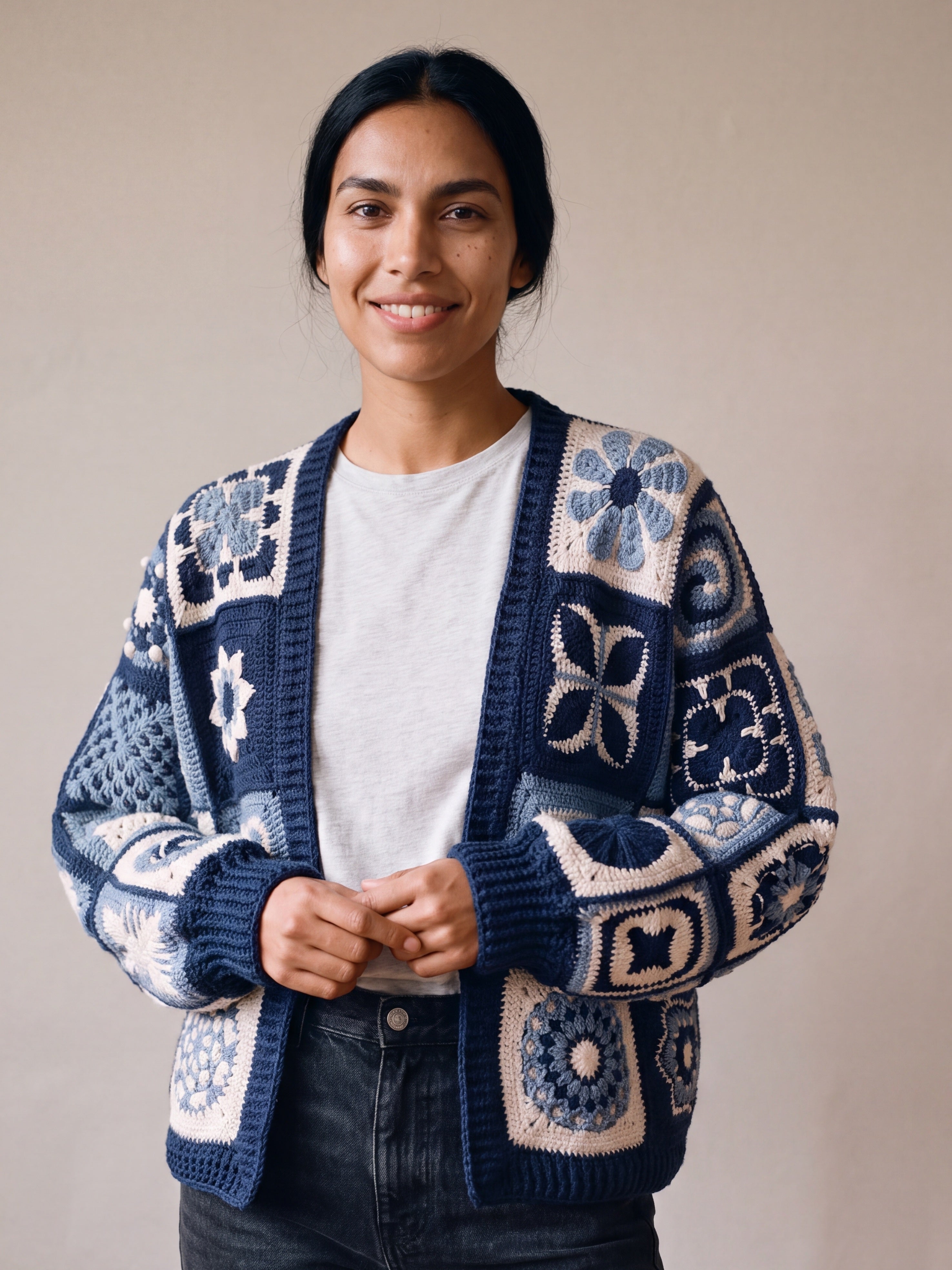 Woman wearing the Sampler Cardigan in Navy, a hand-crocheted granny-square cardigan, over a plain t-shirt and jeans