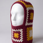 Burgundy and mustard granny square balaclava on a display head, open face and deep neck section — handmade by Ana Chic