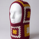 Burgundy and mustard granny square balaclava on a display head, open face and deep neck section — handmade by Ana Chic