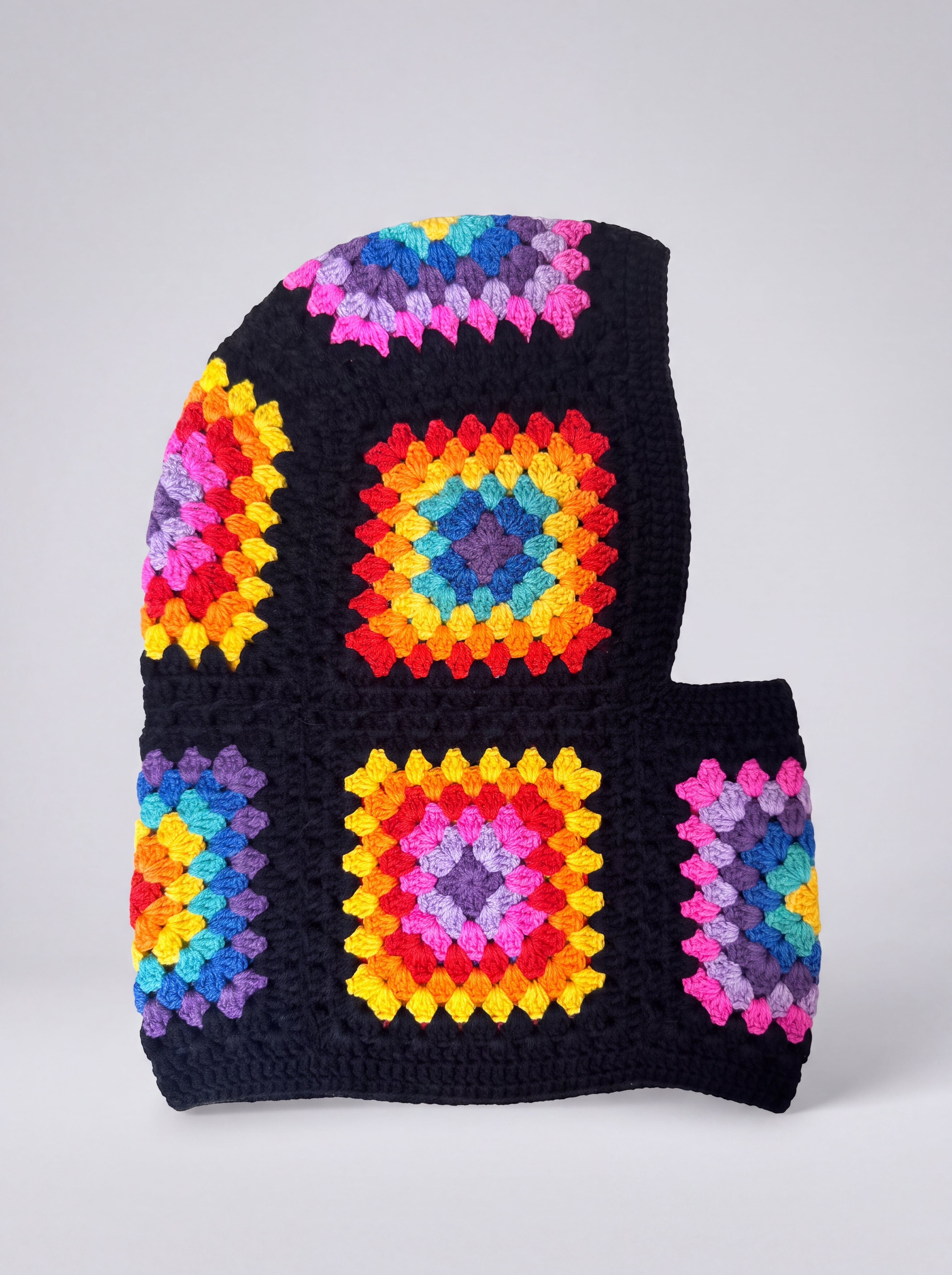 Black rainbow granny square balaclava laid flat, side view of the hood — handmade by Ana Chic
