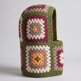 Olive green granny square balaclava standing on its own, back view of the hood — handmade by Ana Chic
