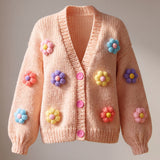 Daisy Peach cardigan front — peach chunky hand-knitted wool cardigan with pastel puff-stitch flowers and pink buttons, handmade by Ana Chic