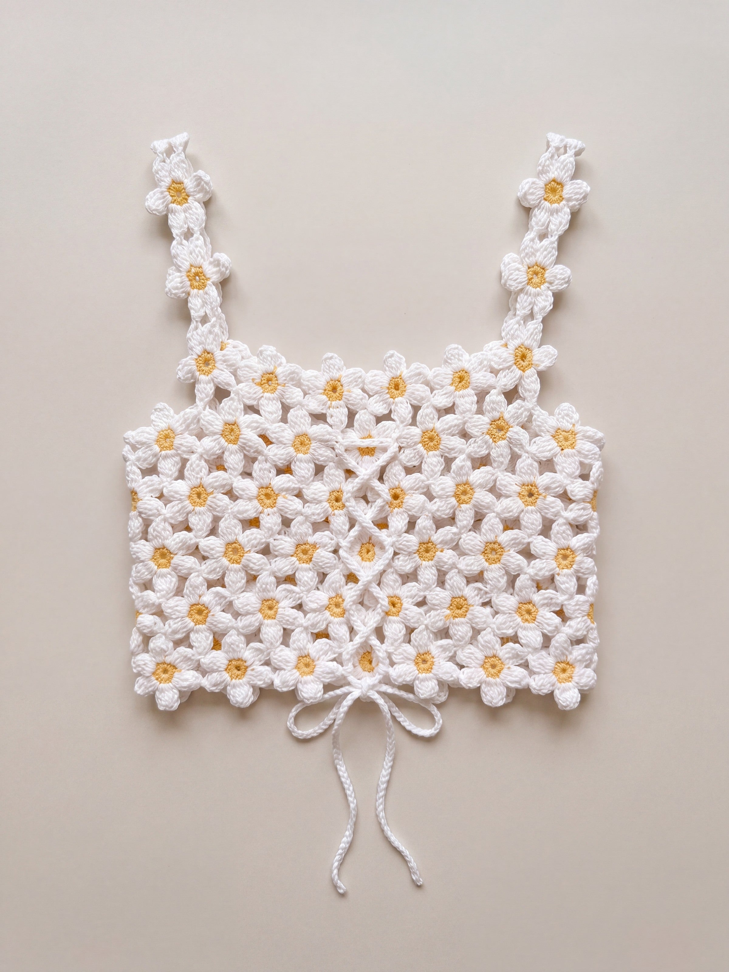 Back of the Daisy crochet crop top, laced with a crocheted cord and tied in a bow