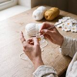 Hands crocheting a single daisy motif for the Daisy crochet top