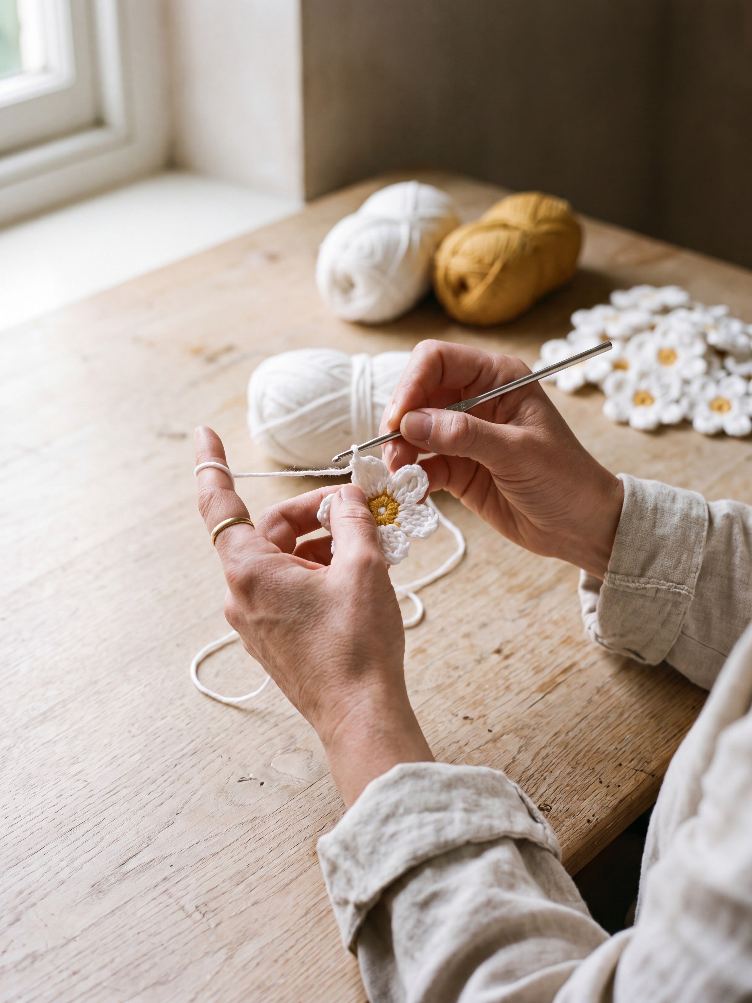 Hands crocheting a single daisy motif for the Daisy crochet top
