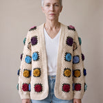 Woman wearing the cream rose granny-square cardigan open over a white V-neck tee and light-blue jeans — handmade by Ana Chic