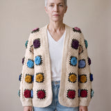 Woman wearing the cream rose granny-square cardigan open over a white V-neck tee and light-blue jeans — handmade by Ana Chic